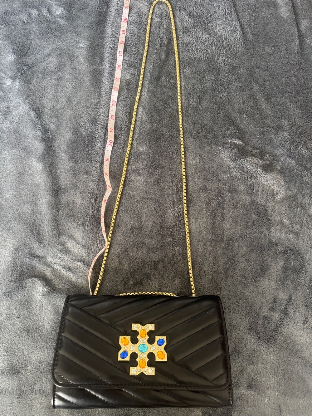 Black Quilted Crossbody Bag with Gold Chain and Decorative Gem Emblem